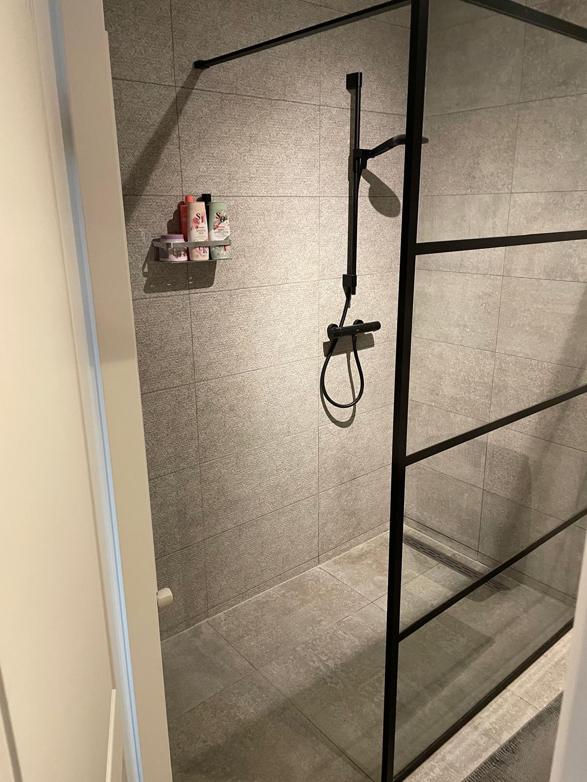 Modern bathroom with walk-in shower and tiled walls