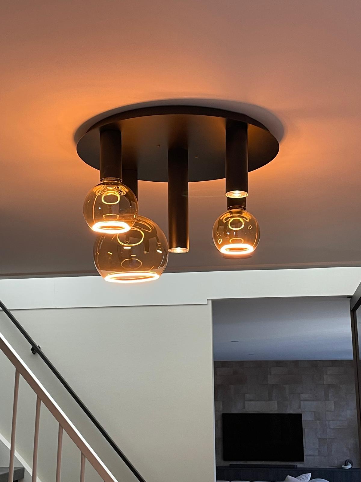 Installation of ceiling lights in progress on a construction site